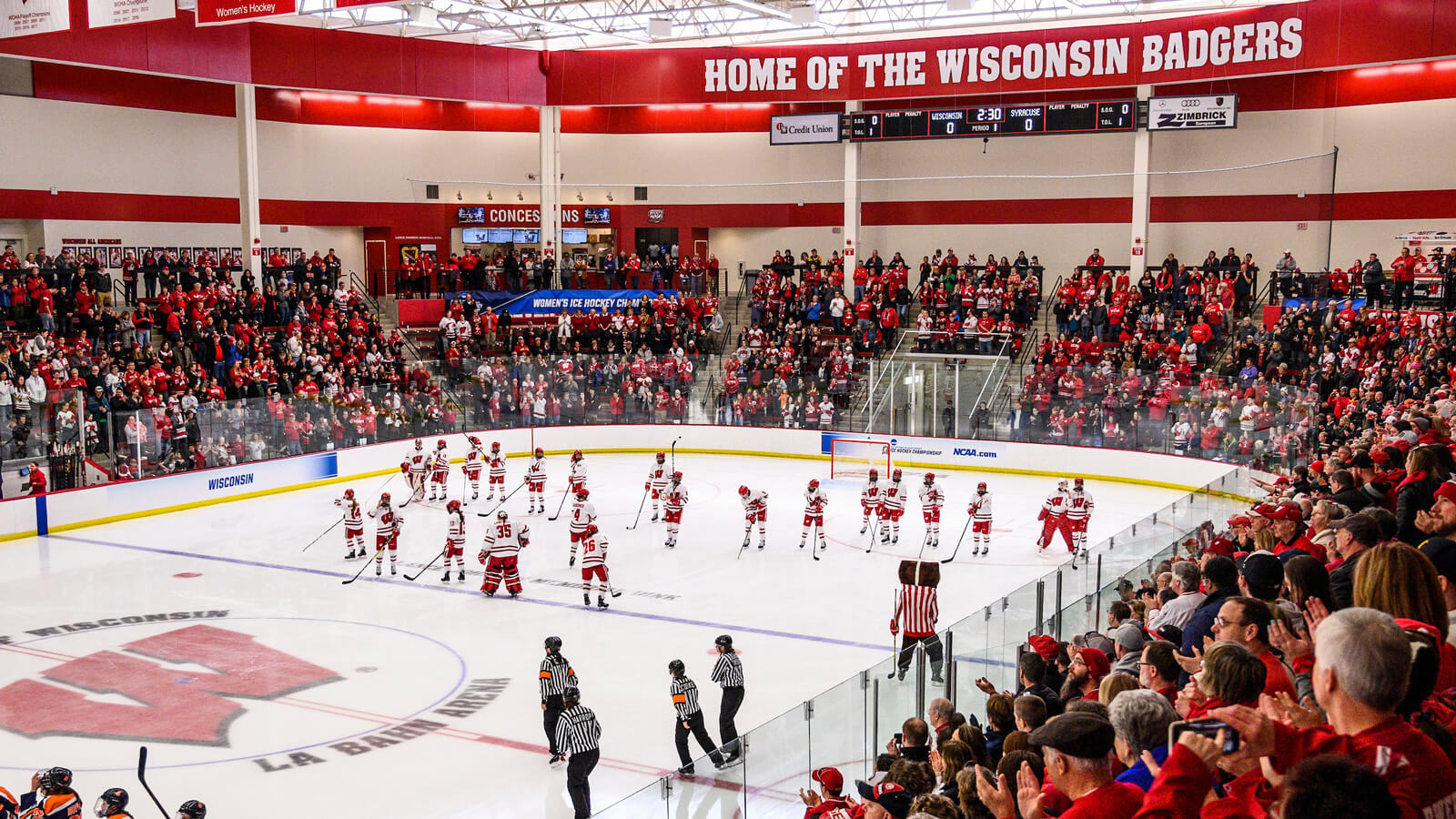 The women's ice hockey team take to the ice in front of a standing crowd at the women's-only hockey rink.